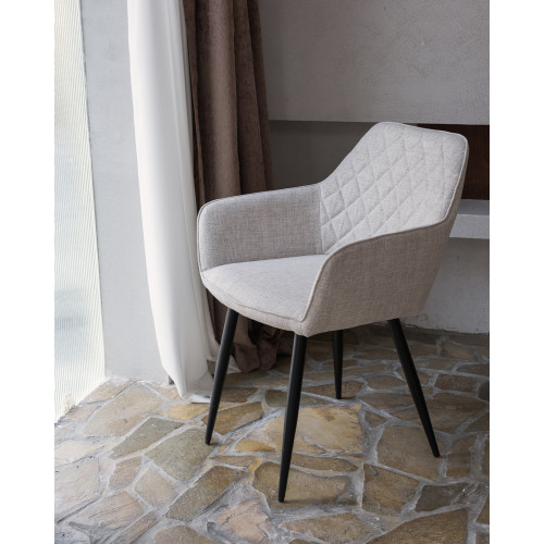 Chaise contemporaine en tissu beige avec dossier matelassé et pieds en métal noir – Confort et design moderne